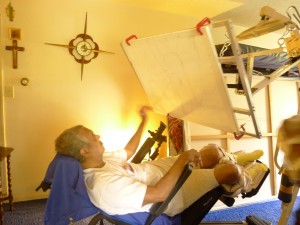 Figure 2: Client using the modified easel from his wheelchair in a reclined position.