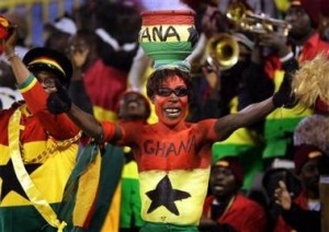 A Ghana fan wearing a pot of burning incense on his head