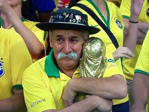 Courtesy of Gaúcho da Copa Twitter - Iconic image of a crying Brazilian fan clutching the World Cup trophy as he mourns Brazil's loss to Germany. 