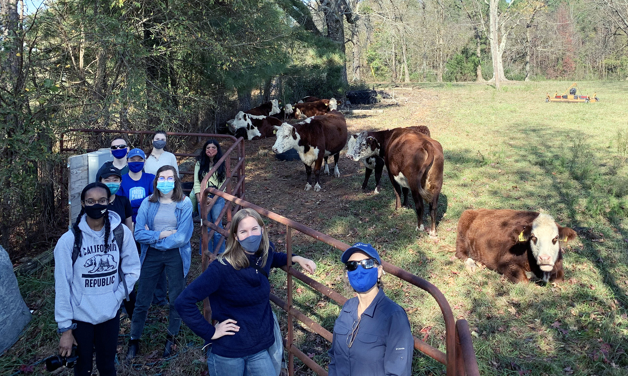 Bass Connections team members wearing masks and visiting a farm as part of their project team's research.