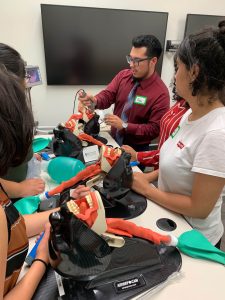 Alex Villeda is working with SALUD Scholars to demonstrate a dental procedure using clinical practice equipment.