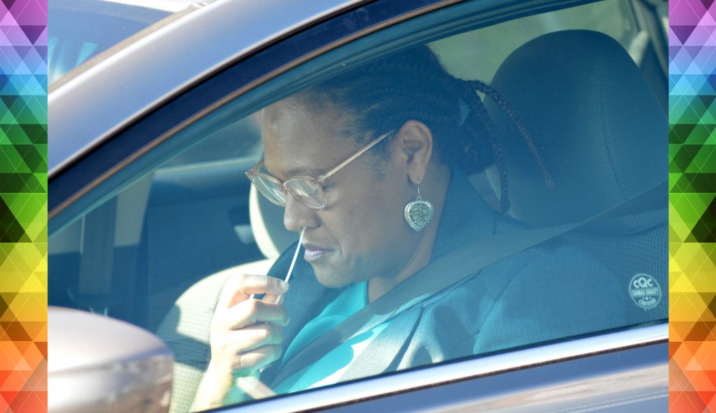 A participant completes a nasal swab test during a drive-through event, part of a study launched in response to the COVID-19 pandemic.