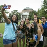 First-year students take a selfie with their first-year advisory councilor after icebreaker and team building activities during Orientation Week on the East Campus lawn.