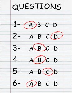 Lined paper with the word Questions and circled letters as answers to multiple choice questions