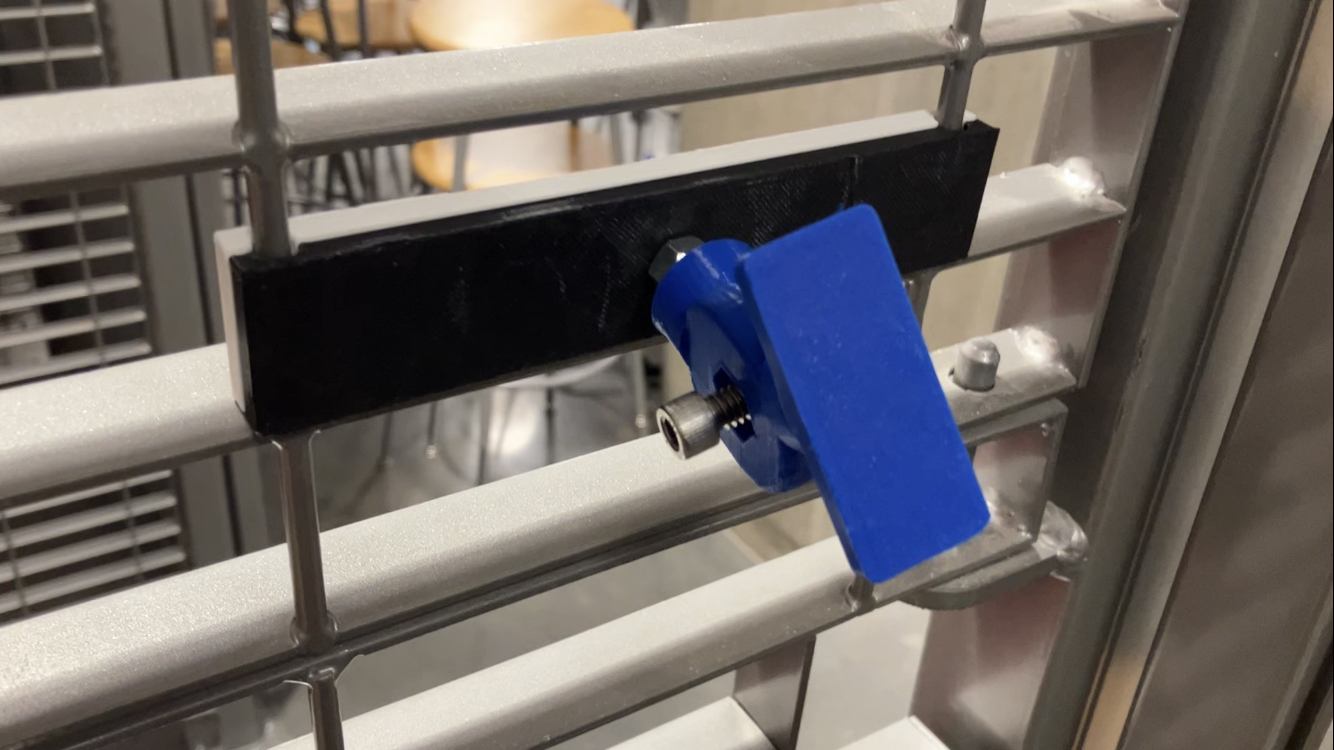3D-printed components screwed onto a slatted cage wall.