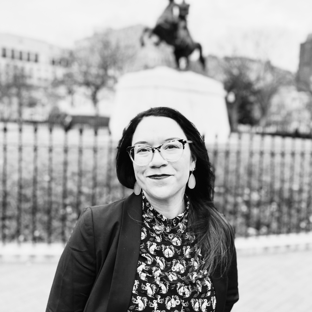 Black and white image of Dr. Lyndsey Gray in front of statue