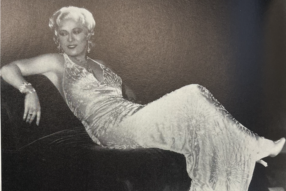 Mae West lounging in a ball gown.