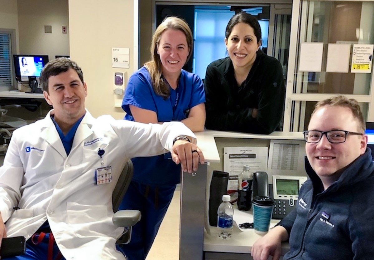 Group photo of four trauma surgeons standing together in the hospital