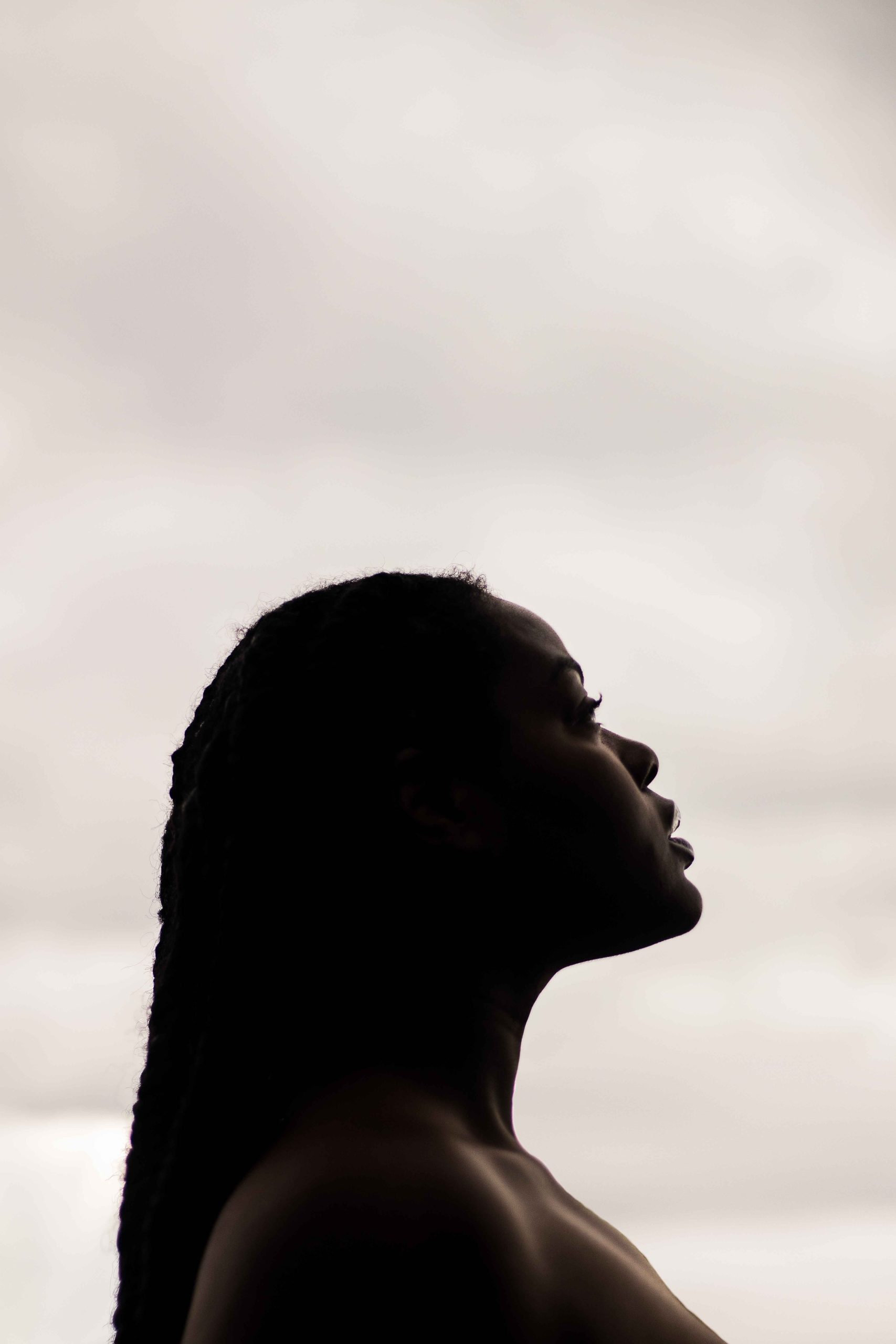 nude woman seen in profile from the shoulders up looking up into the distance